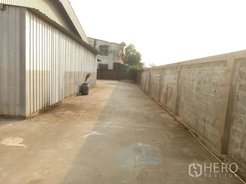 工厂 出租在Lat Lum Kaeo, Pathum Thani - 金属外墙旁的服务通道通向后院。