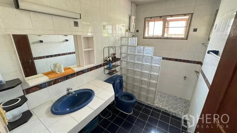 独立式住宅 出售在Mueang Pathum Thani, Pathum Thani - 第二卫浴，蓝色洁具，玻璃砖淋浴区与瓷砖墙面。