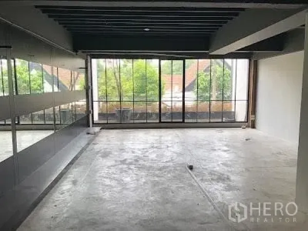 带办公室的家 出租在Watthana, Bangkok - 开放式楼层，混凝土地面，整面落地钢框窗与镜面墙。