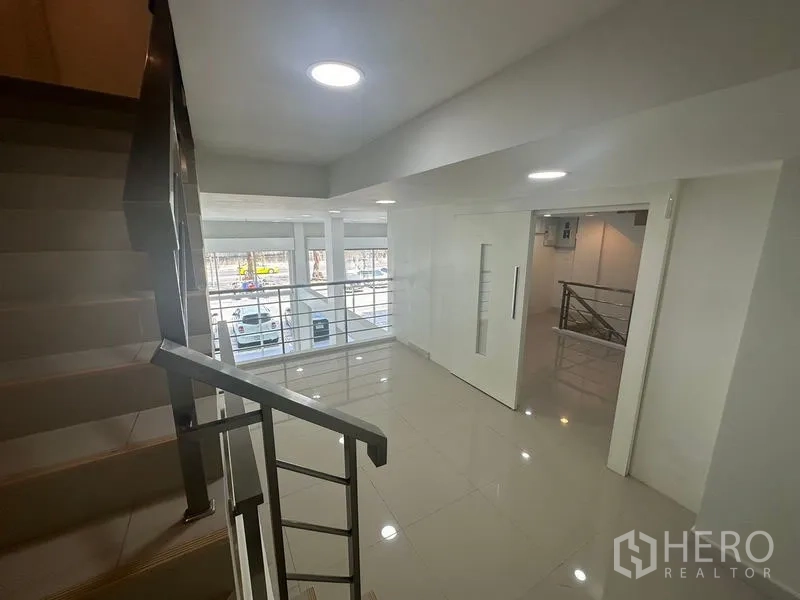 Home Office for rent in Bang Na, Bangkok - Mezzanine corridor with metal railing overlooking front glazing and street.