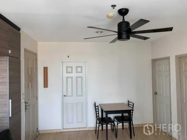 Condominium for rent in Bang Rak, Bangkok - Compact dining nook with table and chairs, ceiling fan and multiple interior doors.