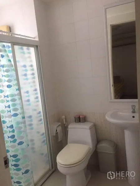 Townhouse for rent in Bang Kapi, Bangkok - Clean bathroom with glass shower enclosure, toilet and pedestal sink.