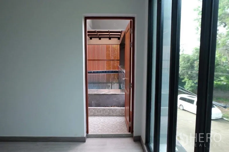 Detached House for sale in Bang Phli, Samut Prakan - Doorway from the house opening to the pool terrace with slatted privacy panels.