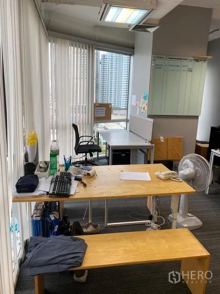 Office Space for rent in Khlong Toei, Bangkok - Corner workstation beside tall windows offering skyline views and natural light.