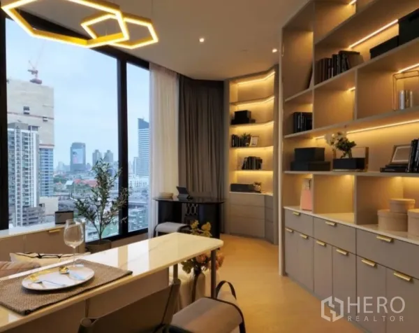 Condominium for rent in Din Daeng, Bangkok - Dining bar and sofa facing skyline views with warm backlit shelves along the wall.