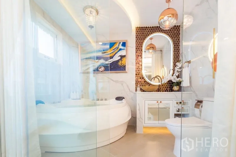 Townhouse for rent in Lat Phrao, Bangkok - Luxury bathroom with round soaking tub, marble walls, gold fixtures and oval mirror.