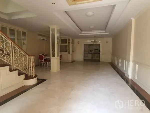 Townhouse for rent in Huai Khwang, Bangkok - Open-plan living area with marble floors, coffered ceiling and recessed lighting.