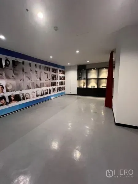 Retail Space for rent in Watthana, Bangkok - Showroom area featuring a photo‑mural wall, display shelving, and a red curtain partition.