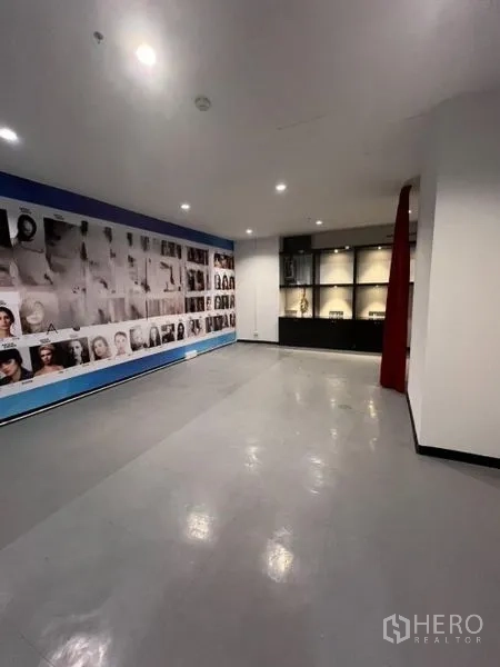 Retail Space for rent in Watthana, Bangkok - Showroom area featuring a photo‑mural wall, display shelving, and a red curtain partition.