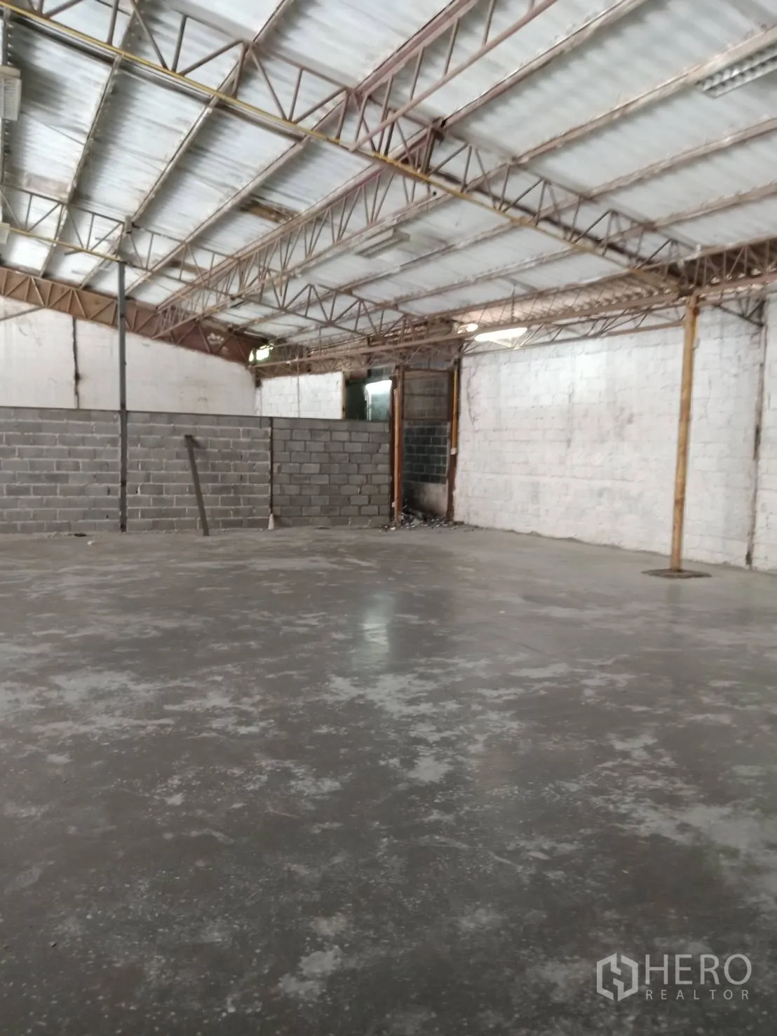 Warehouse for rent in Sai Mai, Bangkok - Open warehouse space with polished concrete floor, block partition walls and metal truss ceiling.