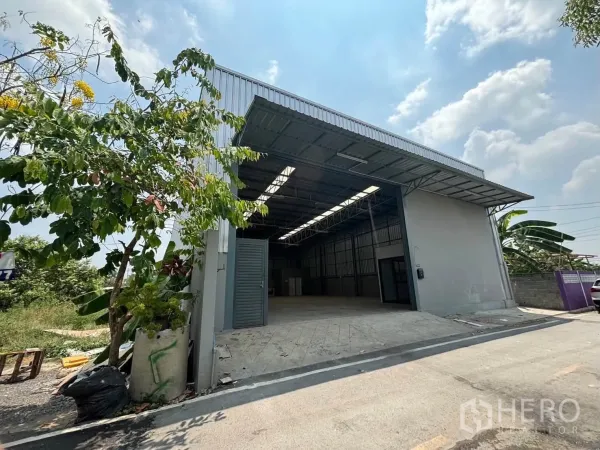 仓库 for rent in Mueang Pathum Thani, Pathum Thani - 仓库外观，入口宽阔带缓坡，配金属屋檐雨棚。