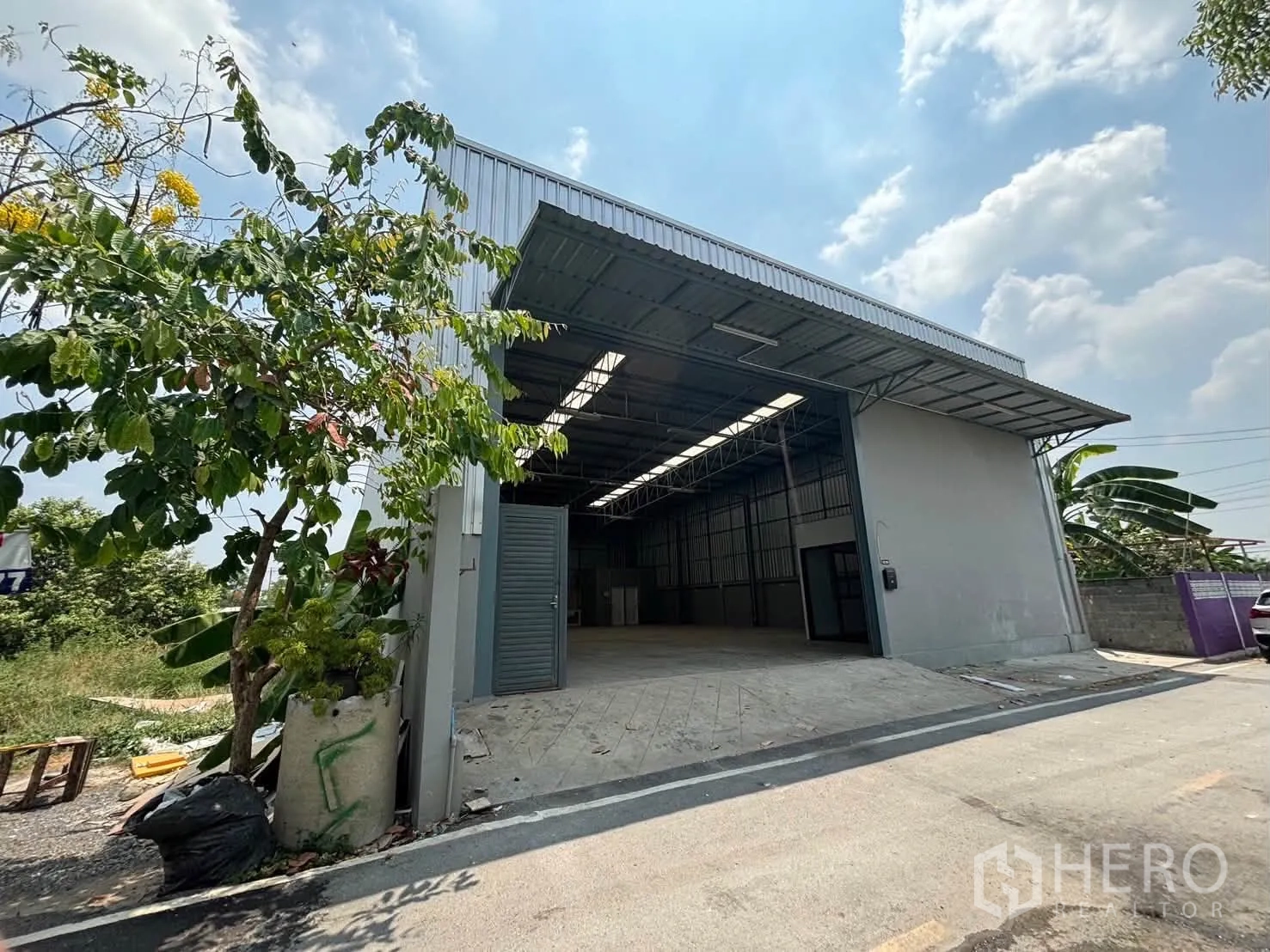 仓库 for rent in Mueang Pathum Thani, Pathum Thani - 仓库外观，入口宽阔带缓坡，配金属屋檐雨棚。