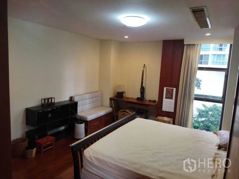 公寓 出租在Pathum Wan, Bangkok - 宽敞卧室，带床、书桌、小沙发与窗外城市景观。