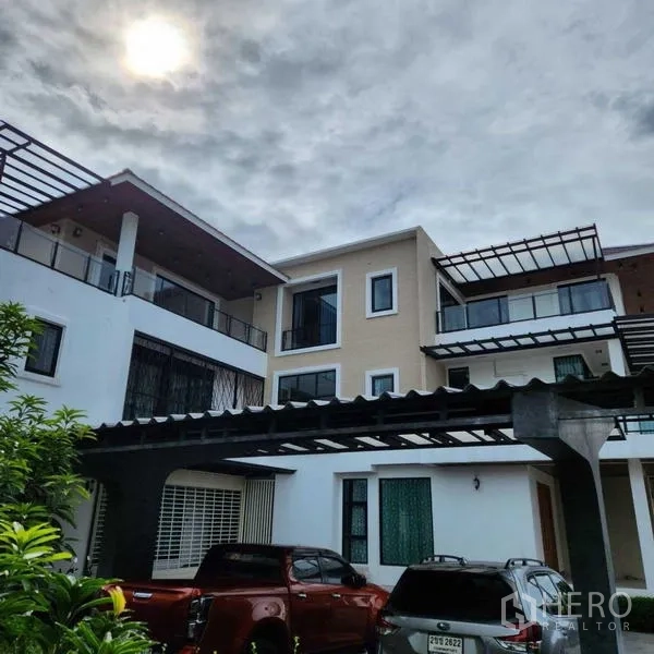 独立式住宅 出售在Phra Khanong, Bangkok - 院内外观，带顶车位与多辆车辆的三层住宅