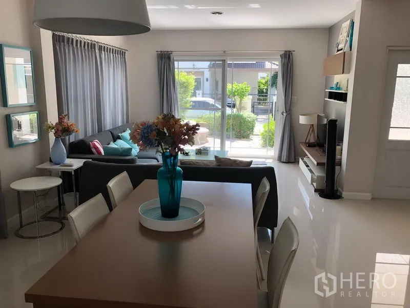 Detached House for rent in Bang Kapi, Bangkok - Bright open-plan living and dining area with sliding glass doors to a small garden patio.
