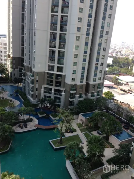 คอนโด ให้เช่าในHuai Khwang, Bangkok - ภายนอกคอนโดมิเนียมสูง มองเห็นสระว่ายน้ำขนาดใหญ่ พื้นที่สีเขียว และวิวเมืองไกลๆ