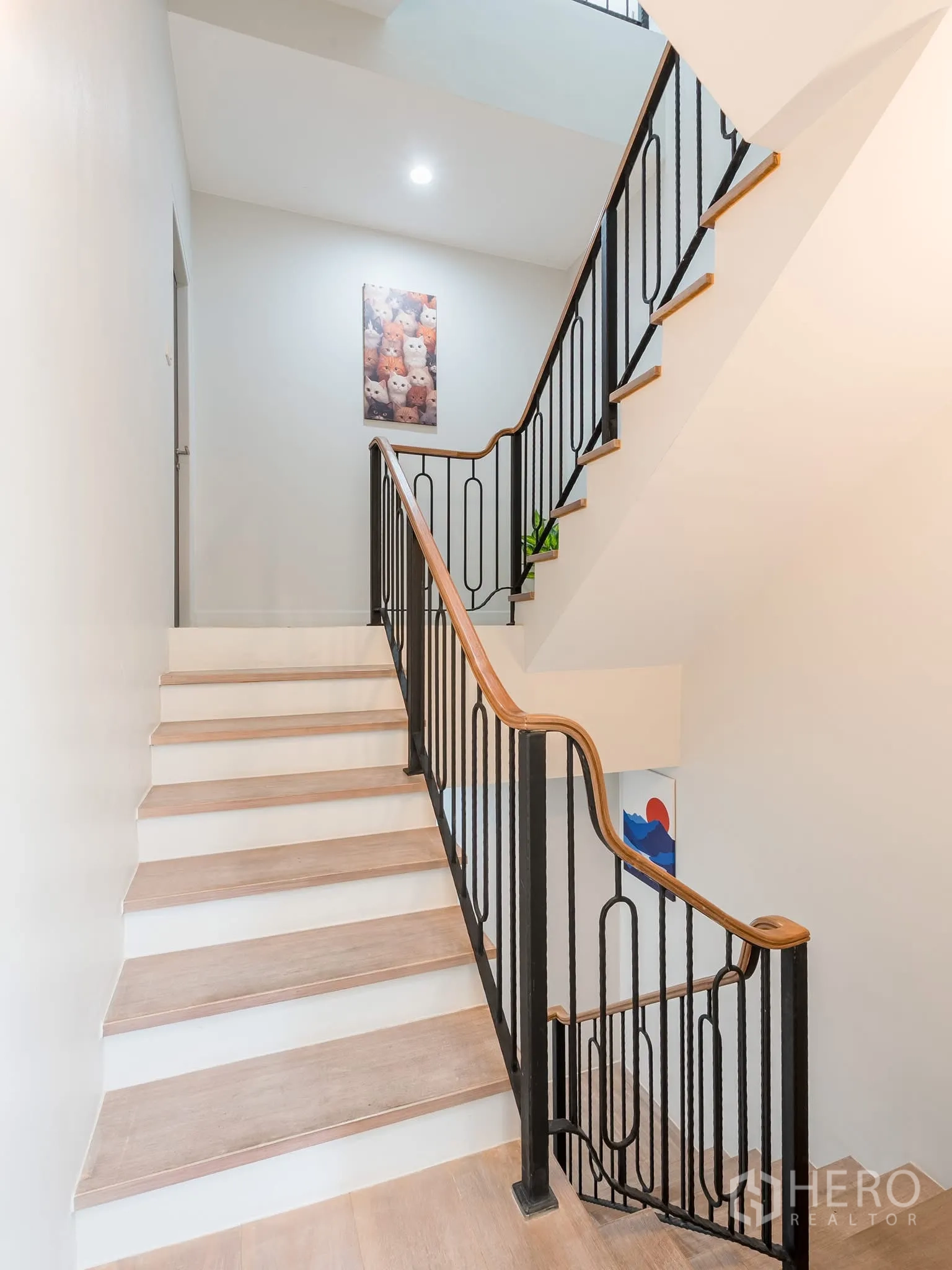 Home Office for rent in Khlong Toei, Bangkok - Staircase with black iron balustrade, recessed lighting and framed artwork.