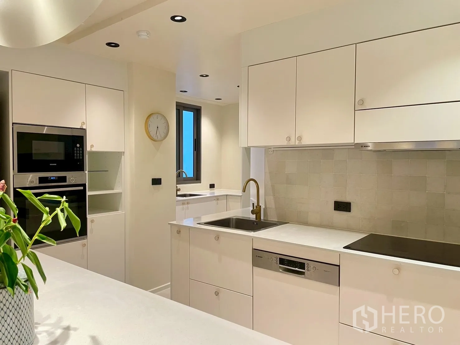 คอนโด for sale in Watthana, Bangkok - ครัวโทนขาวพร้อมเตาไฟฟ้า เครื่องล้างจาน และก๊อกทอง