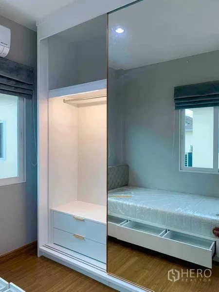 Detached House for rent in Bang Khen, Bangkok - Sliding mirrored wardrobe with illuminated hanging space beside a storage bed.