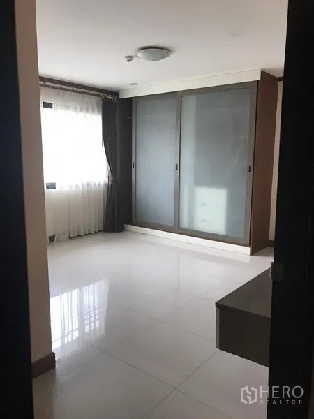 房间 出租在Watthana, Bangkok - 卧室配大幅磨砂玻璃推拉衣柜与纱帘窗户。