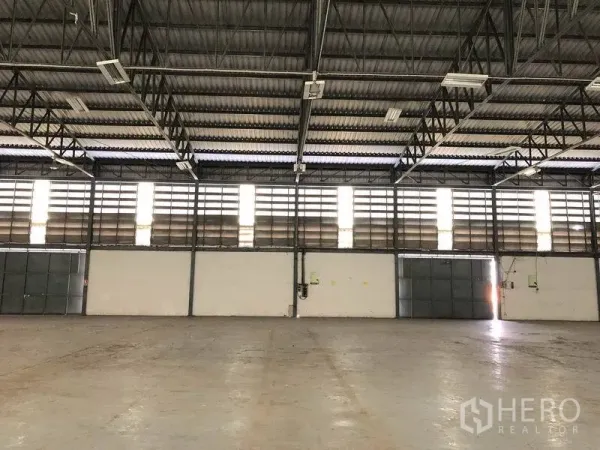 货栈 出租在Khlong Luang, Pathum Thani - 室内墙面设百叶通风窗，钢桁架屋顶，多个出入口。