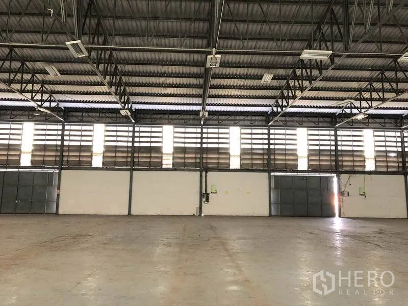 货栈 出租在Khlong Luang, Pathum Thani - 室内墙面设百叶通风窗，钢桁架屋顶，多个出入口。
