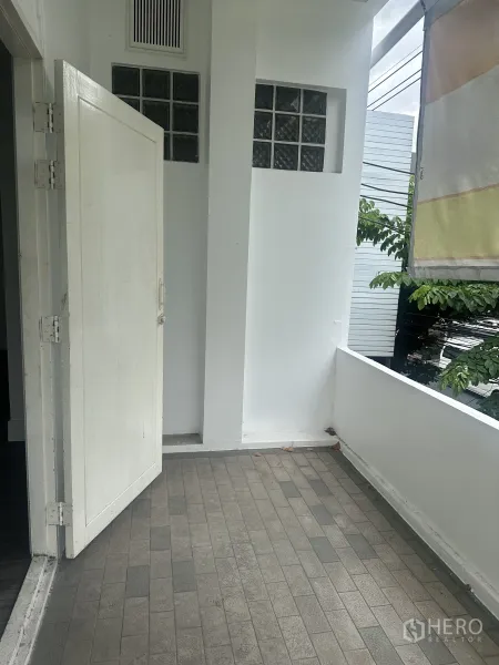 Retail Space for rent in Bang Rak, Bangkok - Small covered balcony with tiled floor and open white door.