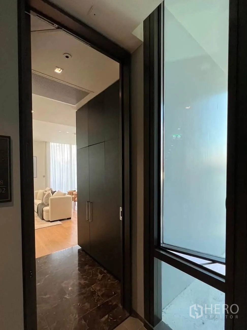 Condominium for rent in Pathum Wan, Bangkok - Entry foyer with marble flooring leading into the bright living space.
