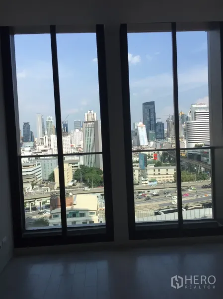 Condominium for sale in Pathum Wan, Bangkok - Floor-to-ceiling windows offering panoramic Bangkok skyline and expressway views.