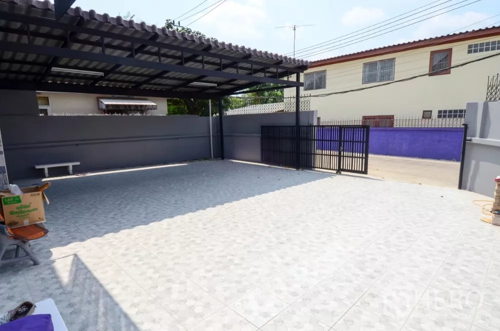 带办公室的家 出租在Lat Phrao, Bangkok - 宽阔铺砖车道与大门，设有可多车停放的遮棚车位。