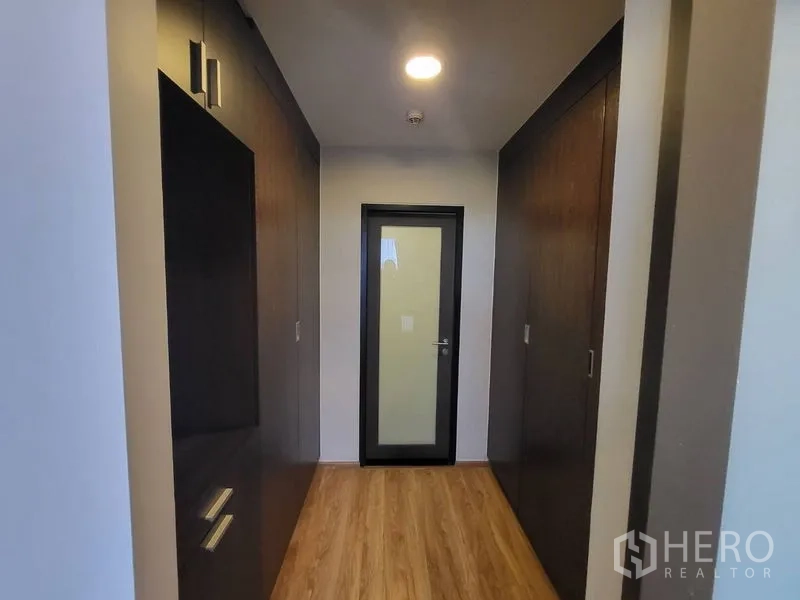 Condominium for rent or sale in Phaya Thai, Bangkok - Hallway with built-in wardrobes on both sides and wood floors.