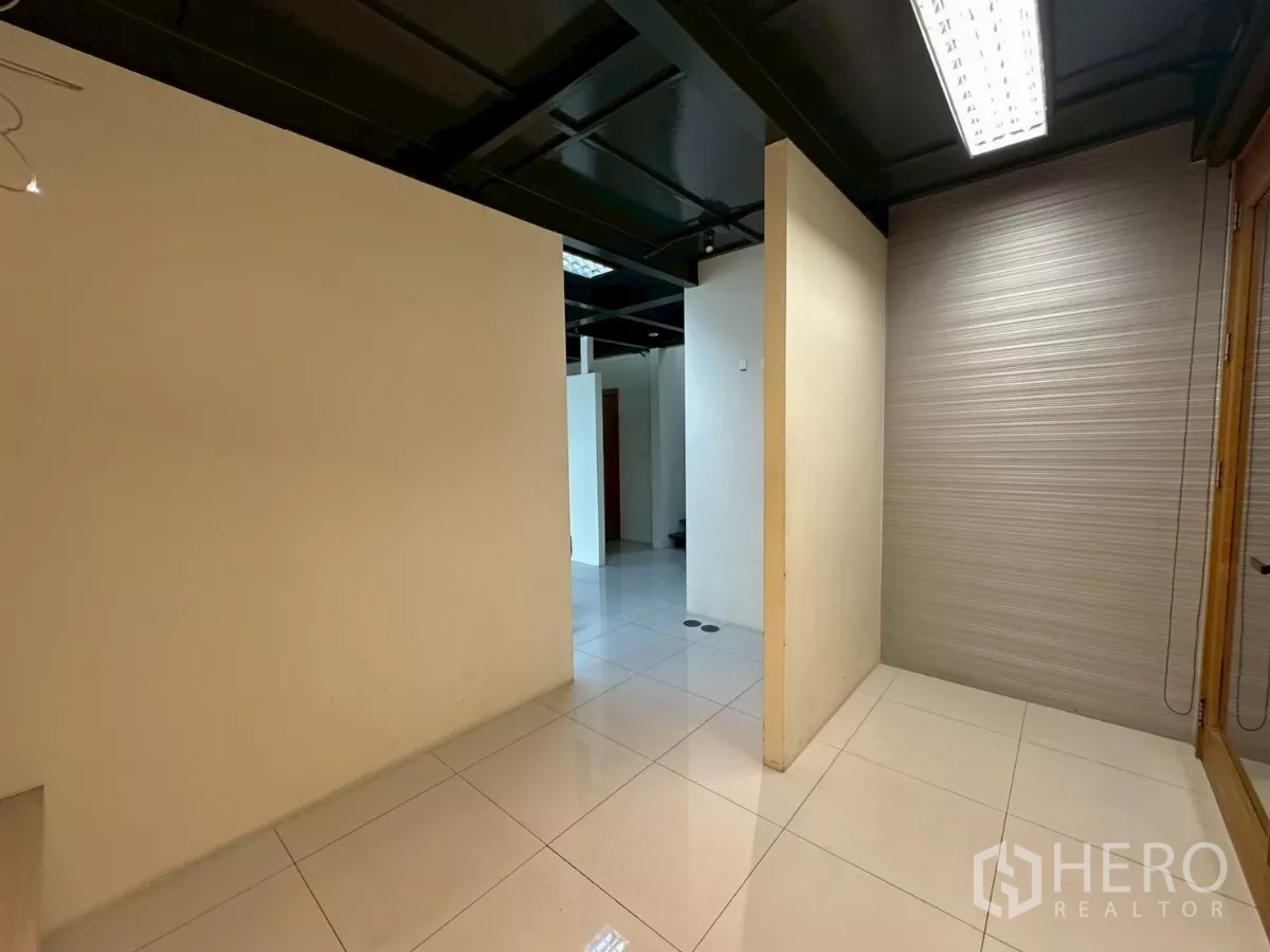 办公空间 出租在Khlong Toei, Bangkok - 复式办公室入口走廊，白色亮面地砖与黑色外露天花。