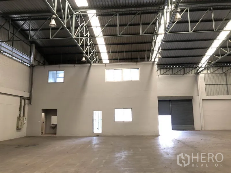 Factory for rent in Pathum Thani - Warehouse showing internal two-storey office block and loading doors.