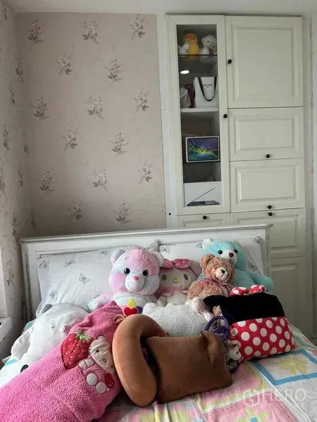Condominium for sale in Huai Khwang, Bangkok - Cozy bedroom with floral wallpaper, white bed and built-in cabinets.