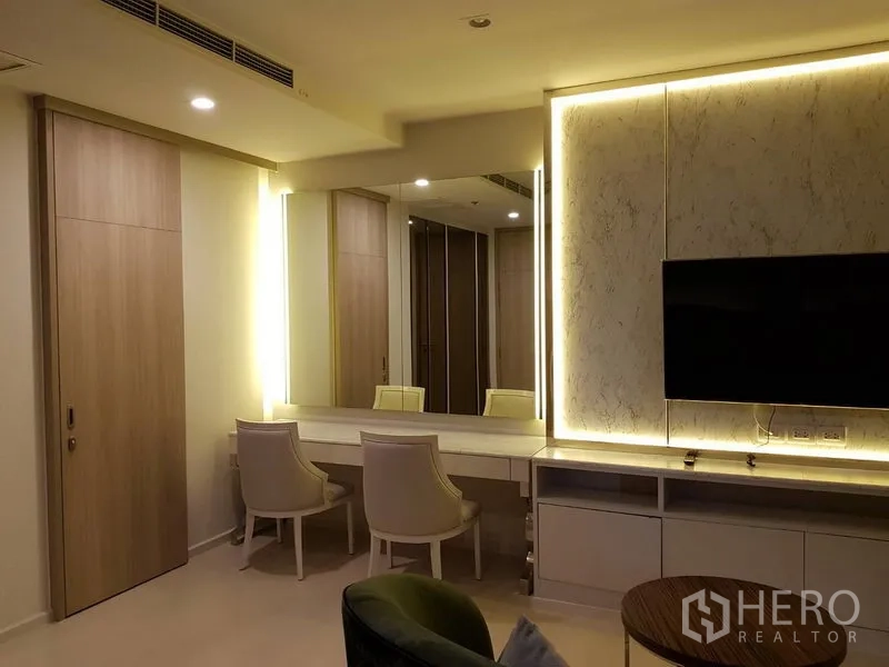 公寓 出租在Pathum Wan, Bangkok - 梳妆区，带背光镜、电视和两把椅子，色调柔和