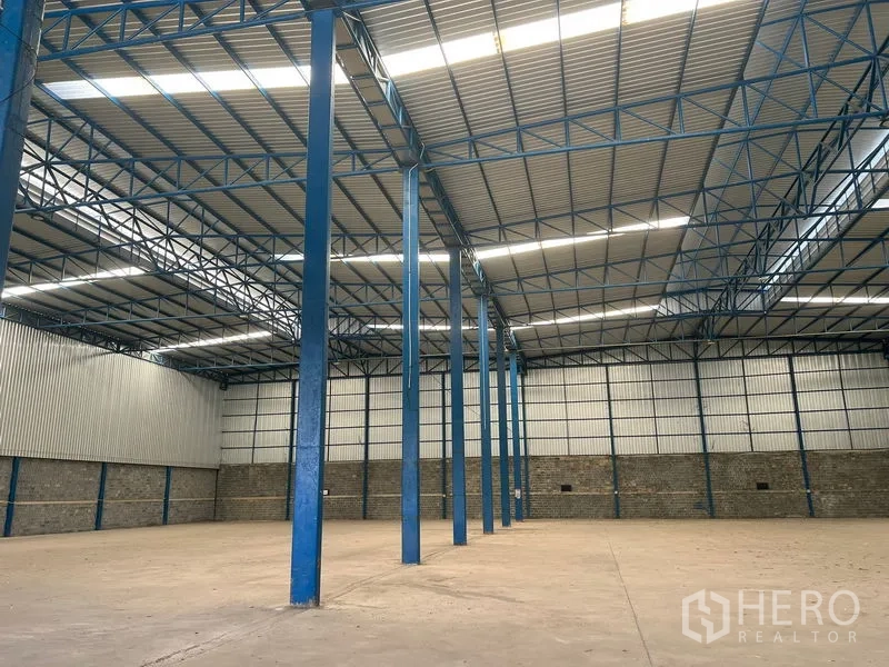 Warehouse for rent in Lat Krabang, Bangkok - Open-plan warehouse with tall pillars, ventilated cladding and smooth concrete floor.