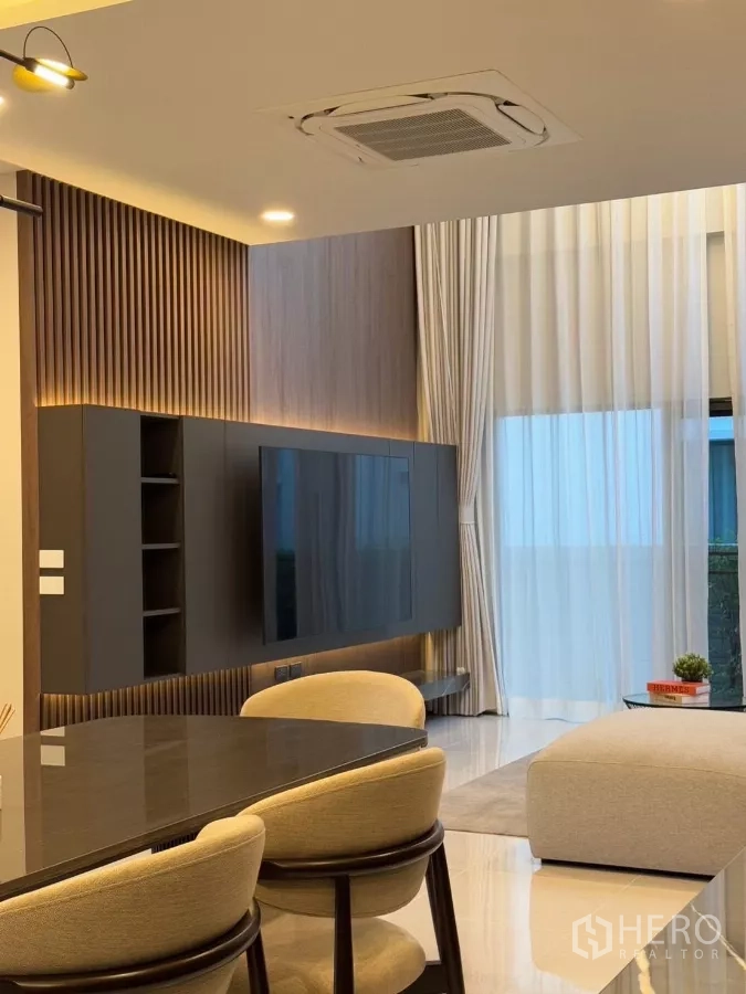 独立式住宅 出租在Bang Phli, Samut Prakan - 电视特色墙与餐椅近景，带跌级天花灯