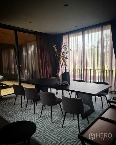 独立式住宅 出售在Lat Phrao, Bangkok - 优雅餐厅，黑色长桌、软包餐椅，落地薄纱窗帘采光充足。