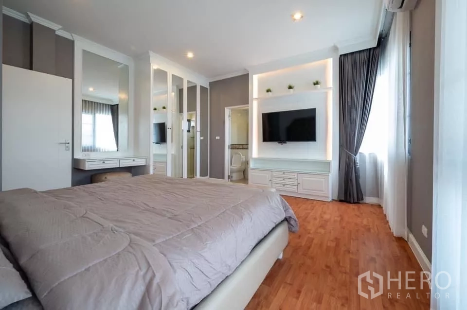Detached House for rent in Prawet, Bangkok - Master bedroom with TV wall, dressing area and ensuite bathroom.
