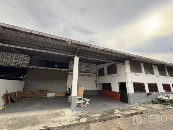 Warehouse for rent in Mueang Samut Prakan, Samut Prakan - Covered loading bay and two-storey office facade at an industrial warehouse in Mueang Samut Prakan.