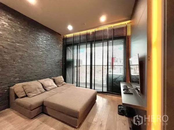 公寓 出租 - 深色客厅，转角沙发，落地窗与百叶，外连阳台与城市景观，石纹特色墙