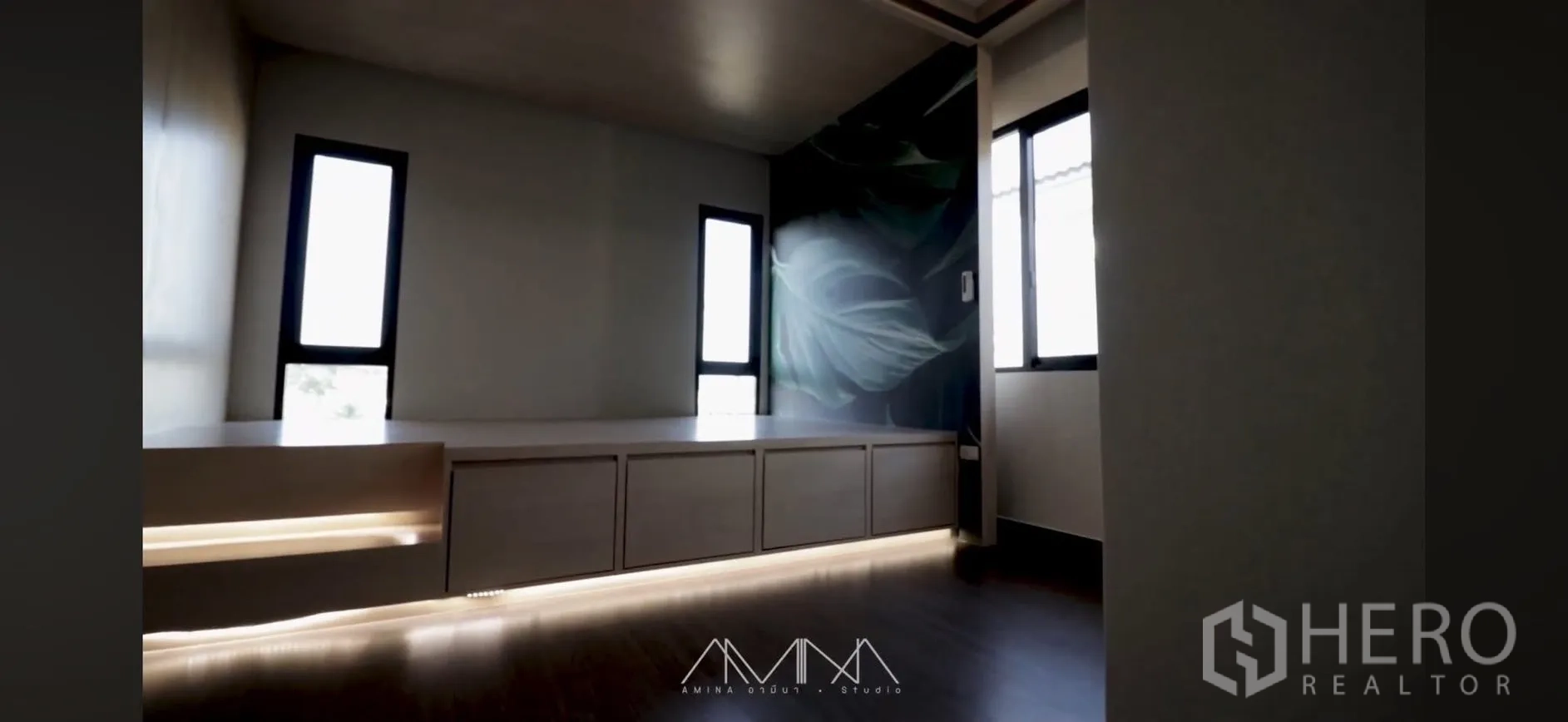 Detached House for rent in Saphan Sung, Bangkok - Bright room with built-in low cabinet and under-cabinet lighting beside narrow windows and a leaf mural.