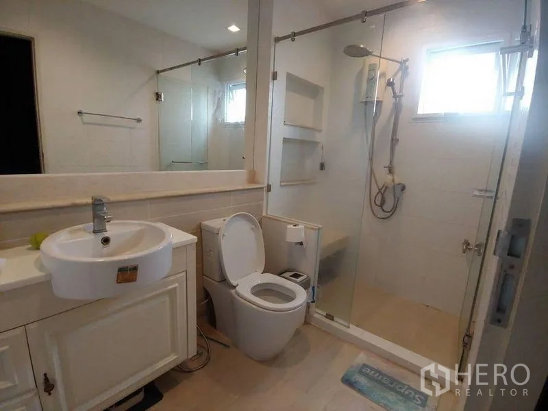 独立式住宅 出售在Khlong Sam Wa, Bangkok - 浴室设玻璃淋浴间、洗手台和马桶。