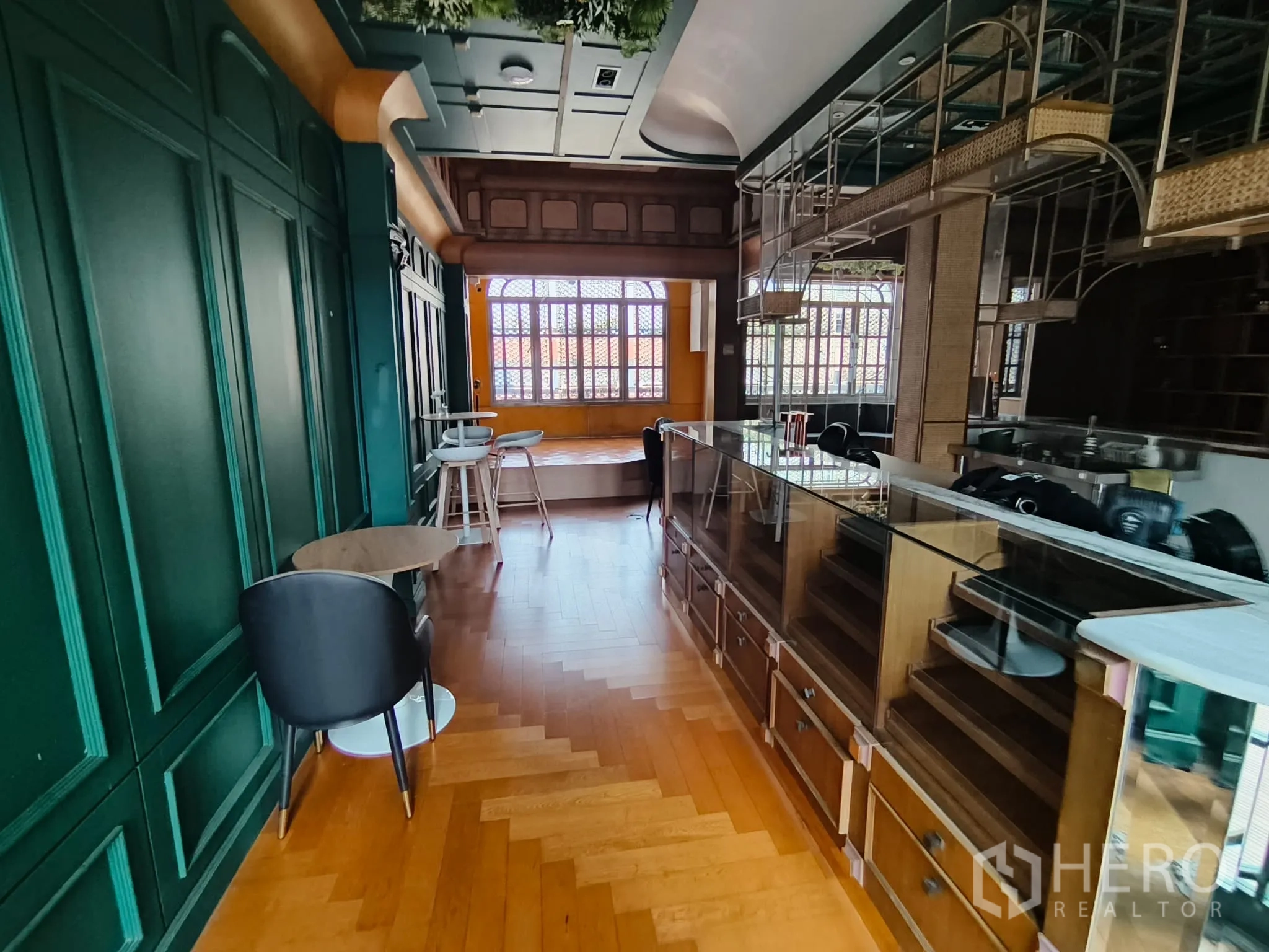 店屋 for rent in Watthana, Bangkok - 吧台风格空间，绿色护墙板、展示柜与人字拼木地板。