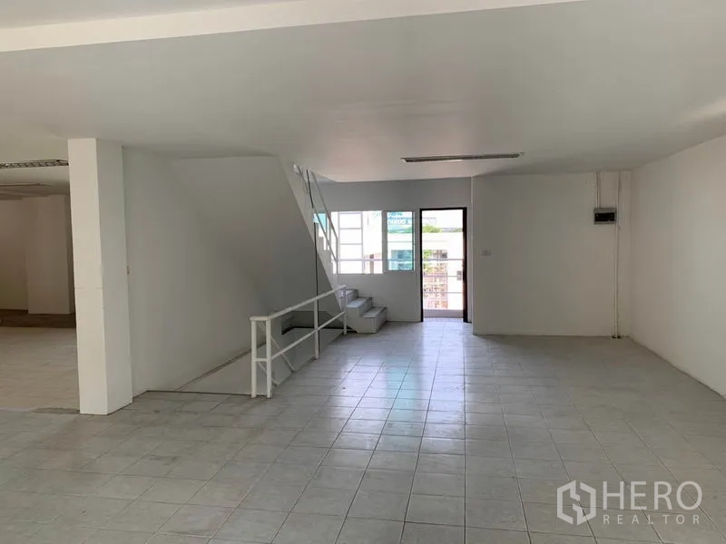 Office Space for rent in Huai Khwang, Bangkok - Open office section featuring a staircase to the upper level, window and exterior door.