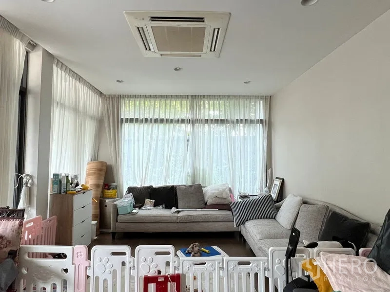 Detached House for sale in Bang Kapi, Bangkok - Sunlit living room with L-shaped sofa, sheer curtains and ceiling cassette air-conditioner.