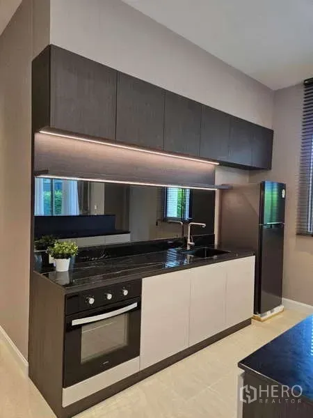 Detached House for rent or sale in Lat Krabang, Bangkok - Compact pantry kitchen with built-in oven, upper cabinets, and under-cabinet lighting.