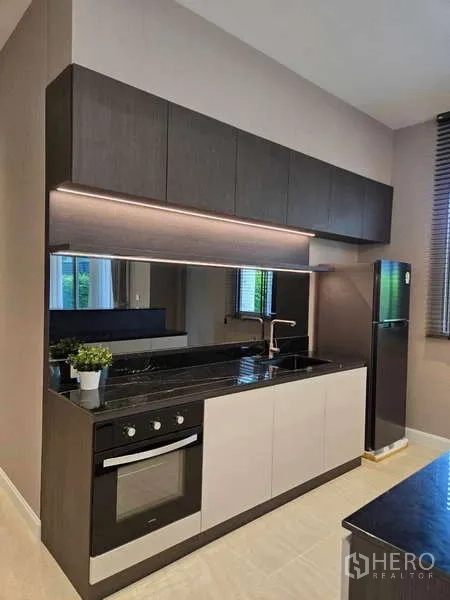 Detached House for rent or sale in Lat Krabang, Bangkok - Compact pantry kitchen with built-in oven, upper cabinets, and under-cabinet lighting.
