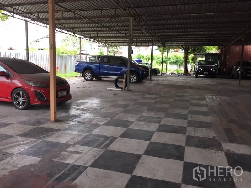 Warehouse for rent in Pathum Thani - Open-sided warehouse with checkerboard floor offering ample parking and loading space.