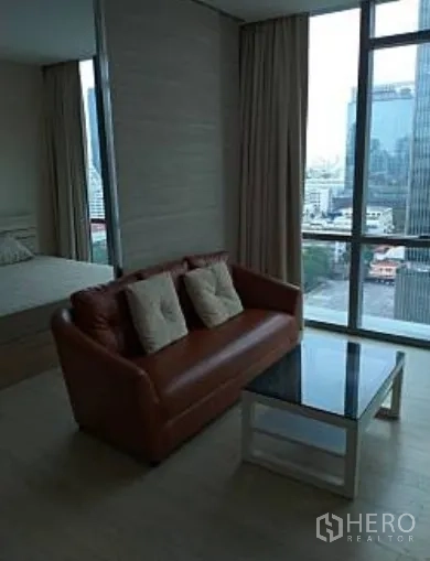คอนโด ให้เช่าในWatthana, Bangkok - มุมนั่งเล่นโซฟาหนัง โต๊ะกลางกระจก หน้าต่างเต็มผนังวิวสกายไลน์เมือง